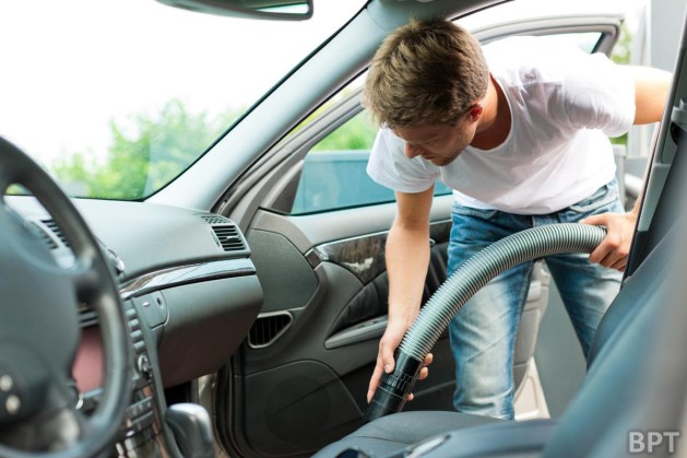 Man cleaning our car with vacuum