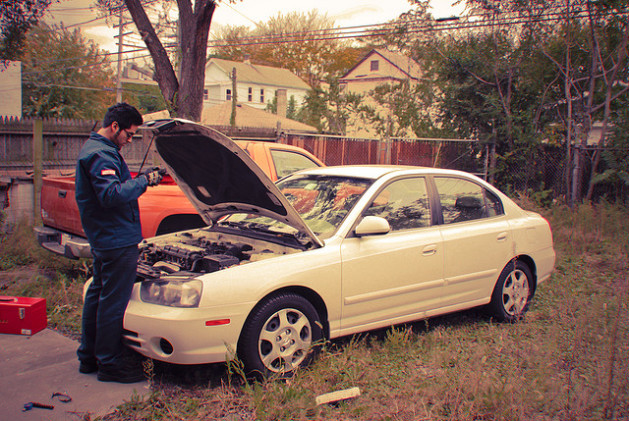 Mechanic working on white car