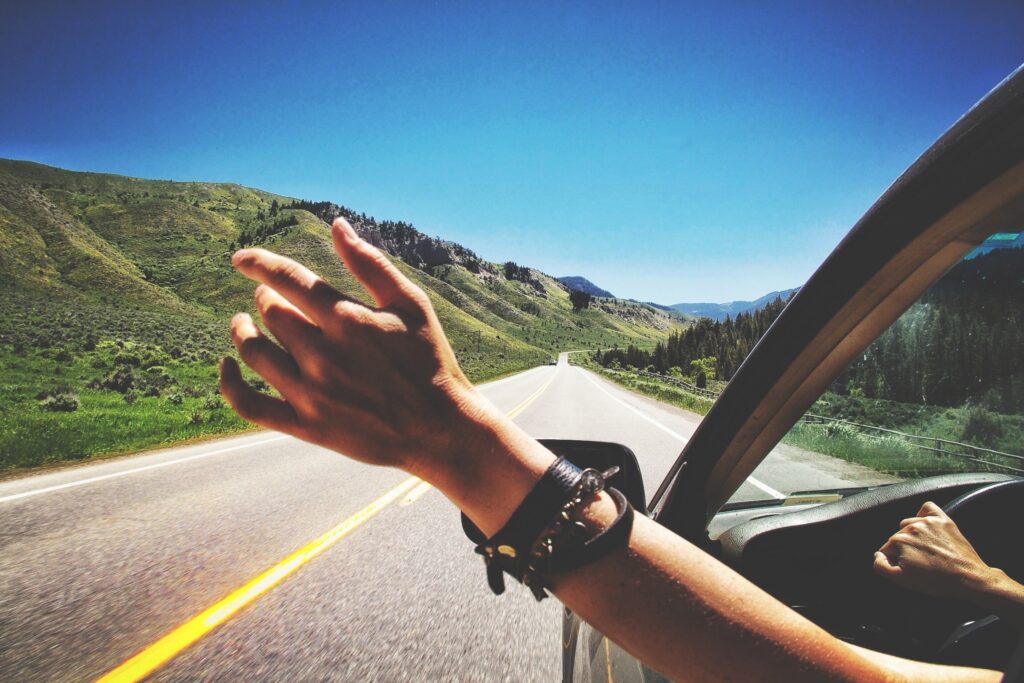 Hand out car window on open road