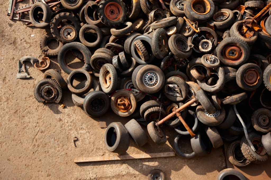 pile of worn and rusted tires and wheels