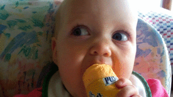 Baby eating something and making a face gif
