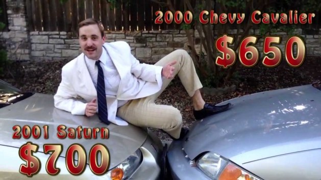Car salesman sitting on two cars