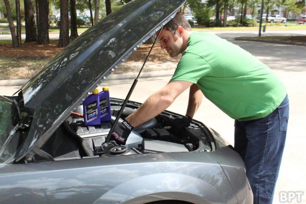 man looking under the hood of a car