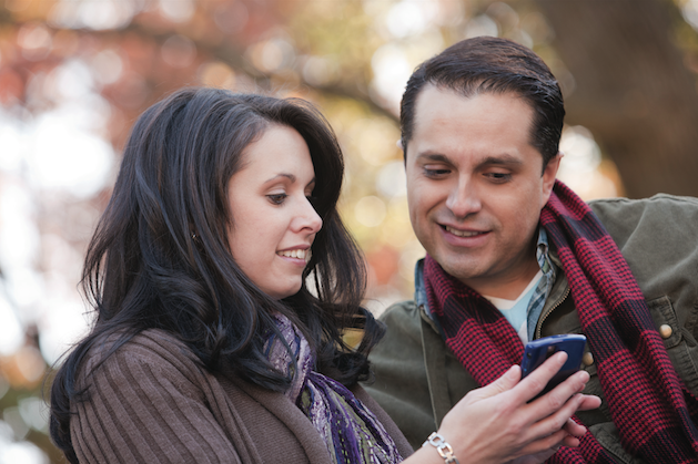 man and woman looking at a smartphone