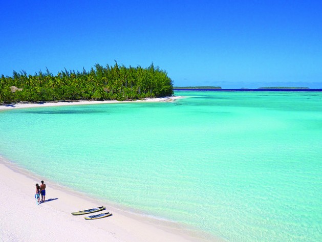 people walking on white sand beach and crystal blue water