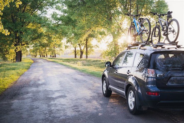 black suv with bike rack on shaded country road