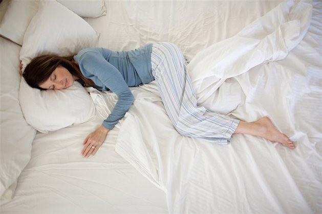 woman sleeping in bed with white sheets