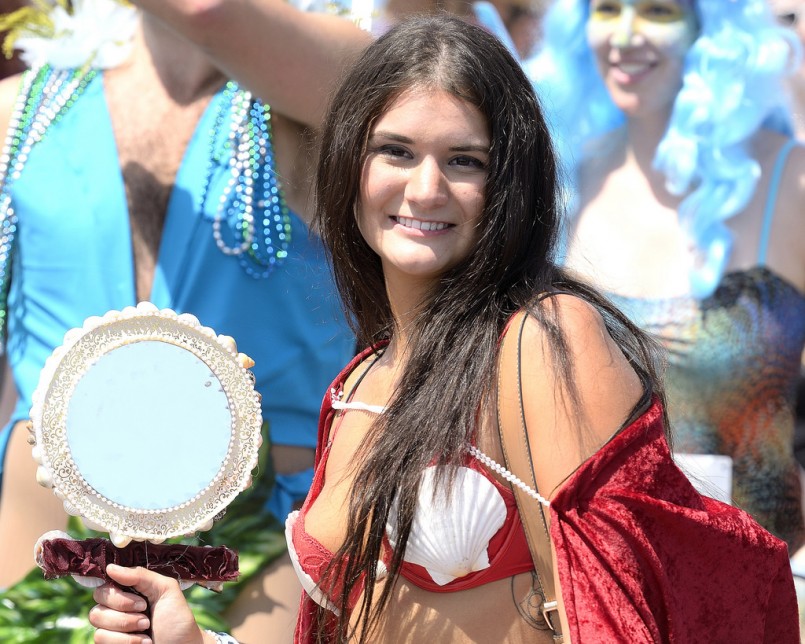 brunette mermaid with red seashell bra holding a mirror