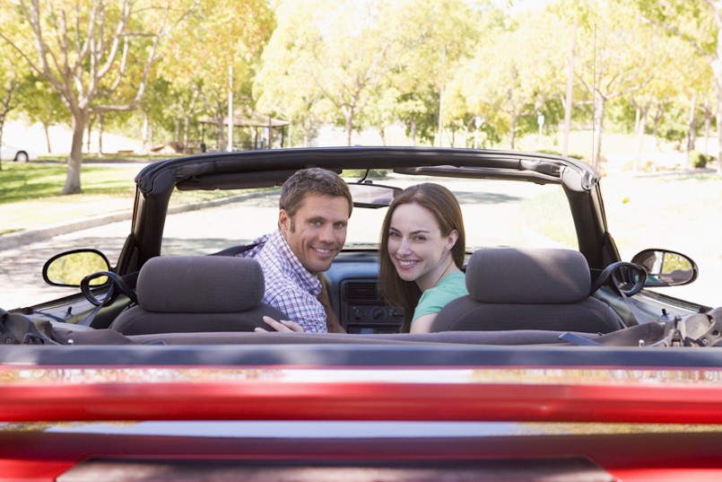 Couple in convertible car smiling