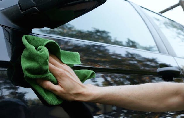 person waxing a car