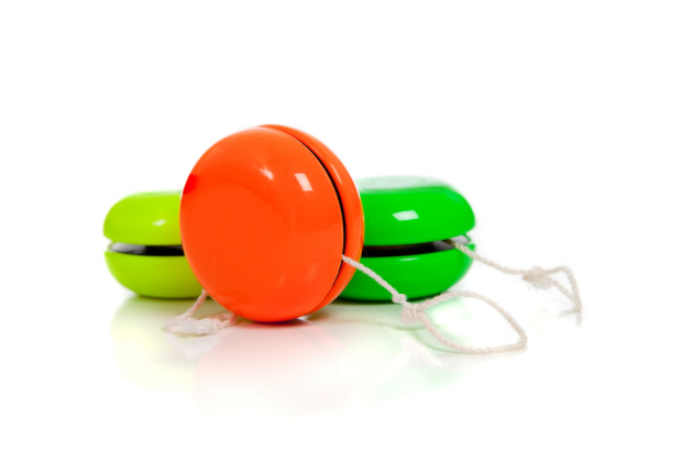 Green and red yoyos on a white background with copy space