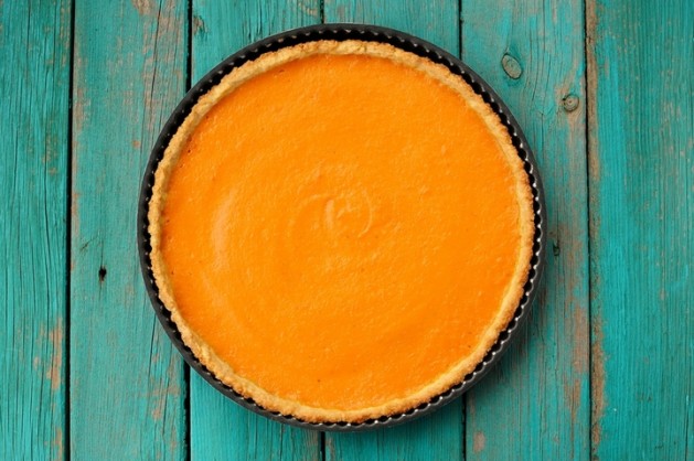 Fresh Round Bright Orange Homemade Pumpkin Pie in Baking Dish on Turquoise Table