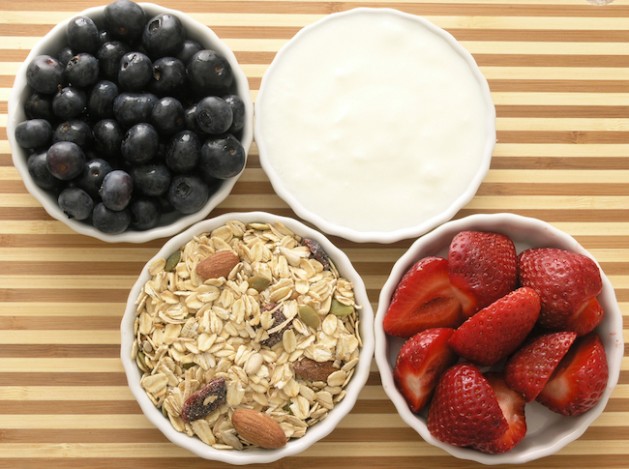 ingredients of a healthy tasty breakfast- blueberries, strawberries, muesli, and yogurt