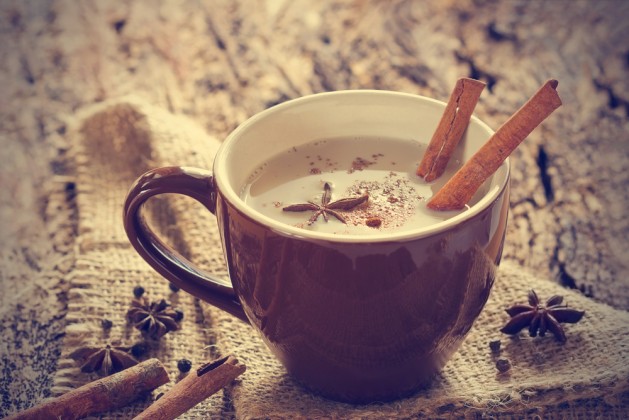 masala chai tea with spices and star Anise, cinnamon stick, peppercorns, on sack and wooden background
