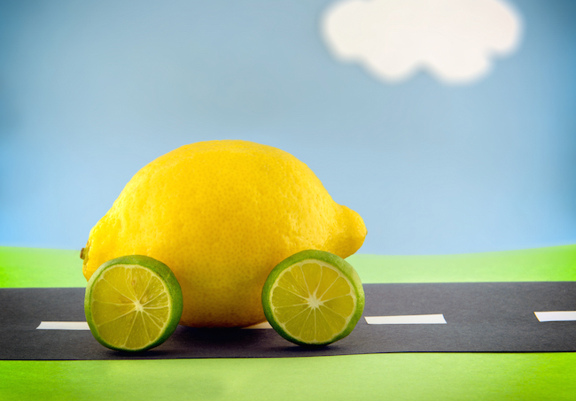 A lemon car with lime wheels driving along a construction paper scene