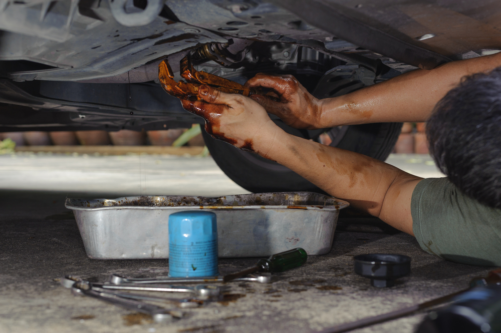 Car mechanic loosen oil filter