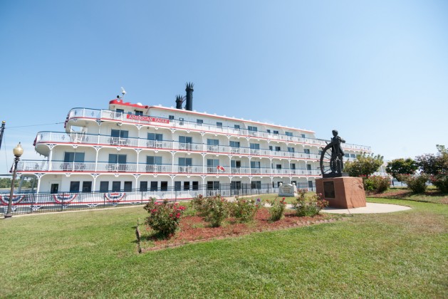 American Eagle paddle wheel riverboat arrives docked by bronze statue Mark Twain Steamboat