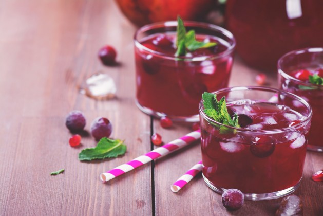 Cranberry and pomegranate cocktail with mint garnish, selective focus. Toned image