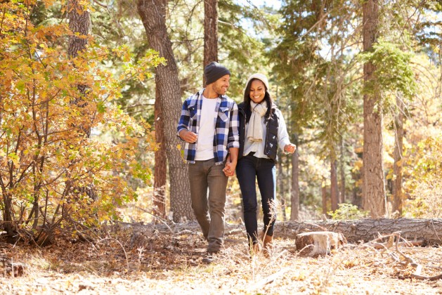 African American Couple Cycling Through Fall Woodland