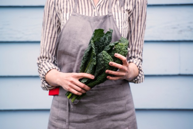 Closeup of Female Hands Holding Bunch of Green Italian Kale