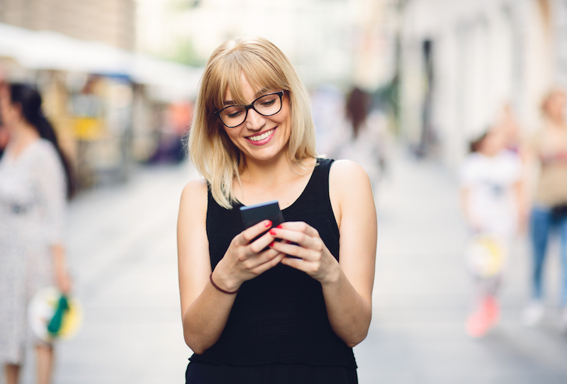 Smiling beautiful urban woman texting on the smart phone, phone, unplug