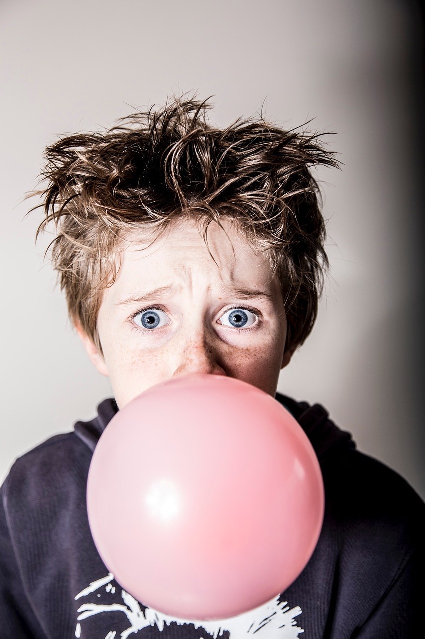 Young boy blowing bubble with chewing gum