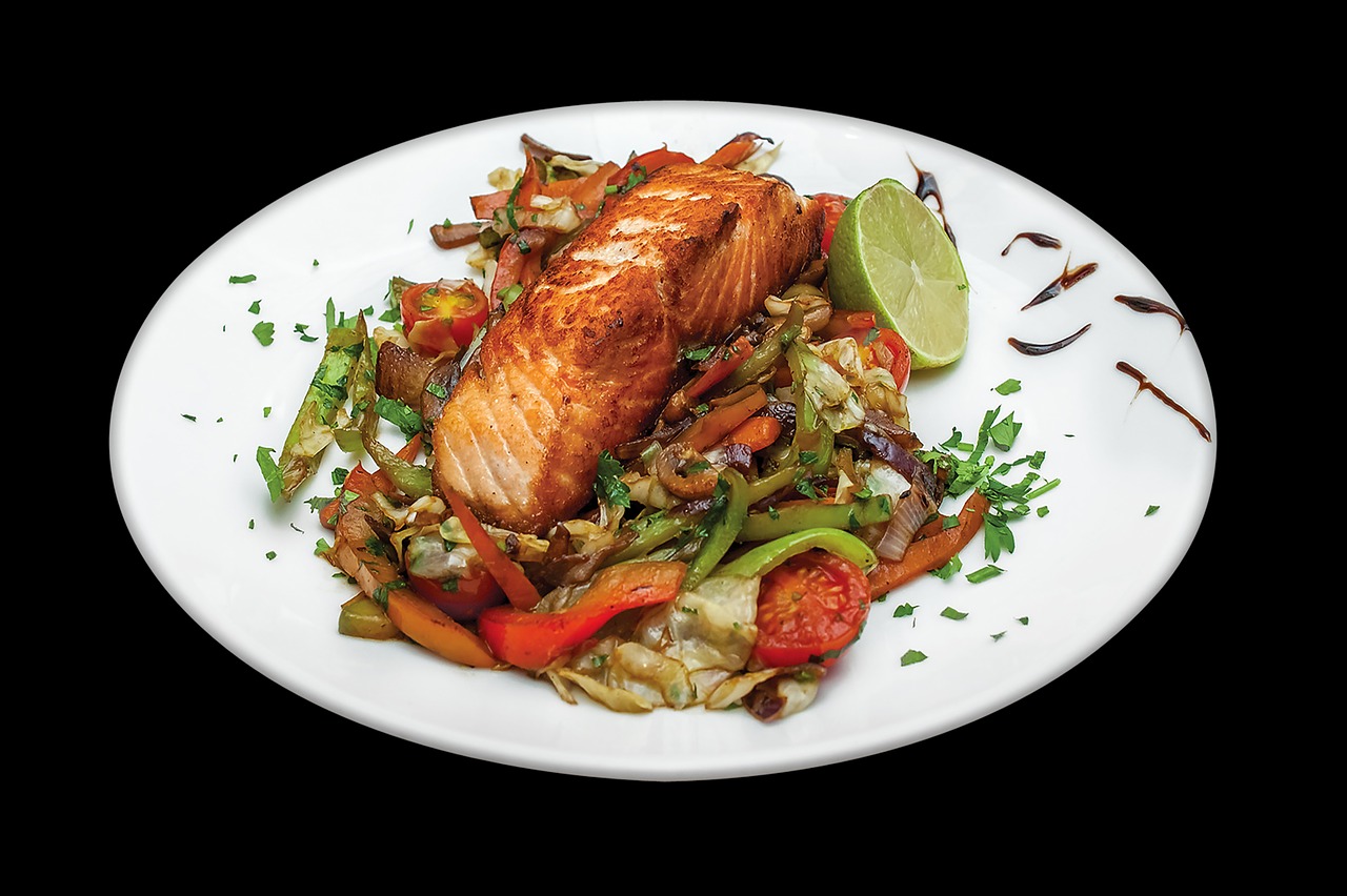 cooked salmon with vegetables on plate