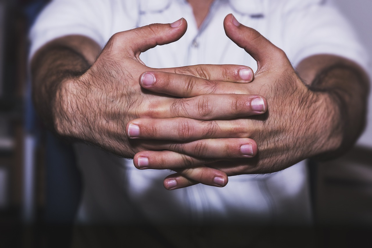 Person's hands out and fingers laced