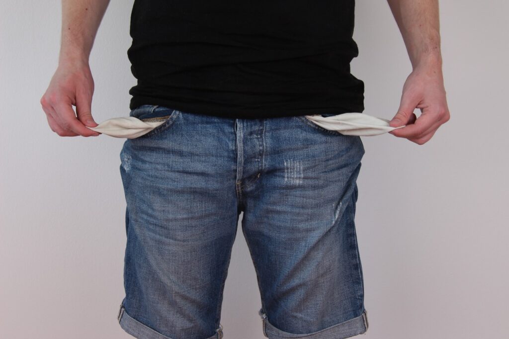 Man pulling out the inside of his pockets showing they are empty
